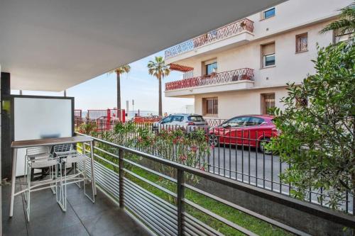 - un balcon offrant une vue sur un immeuble avec des voitures dans l'établissement LE BAY SIDE plein cœur de Juan les Pins en bord de mer, pour familles ou petits groupes, à Antibes