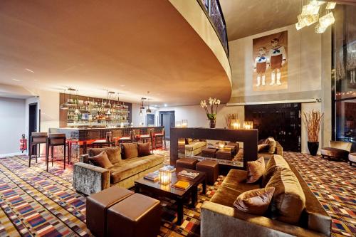 a large living room with couches and a bar at Hotel The Augustin in Brussels