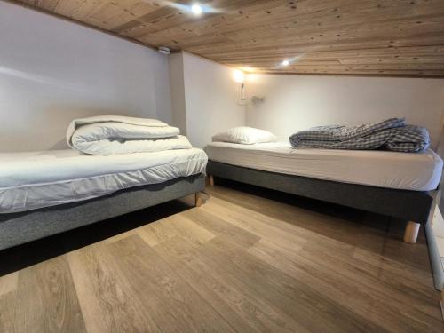 Cette chambre comprend 2 lits jumeaux et du parquet. dans l'établissement Résidence Curling B Tour - Studio rénové · Pieds des pistes · Balcon MAE-8151, à Tignes