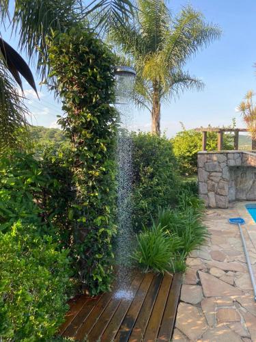 a water fountain in the middle of a garden at Casa de Campo com Piscina in Itupeva