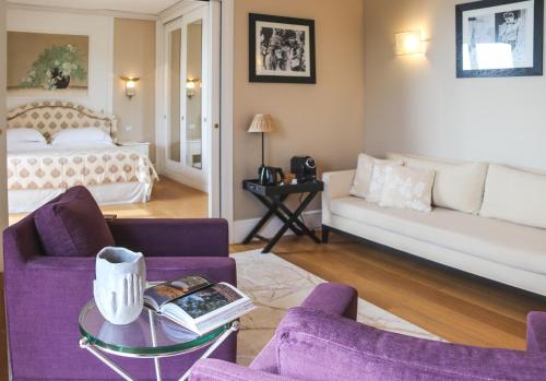 a living room with purple furniture and a bed at Cala del Porto Punta Ala - Preferred Hotels in Punta Ala