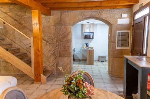 圣埃斯特万德戈尔马斯Hotel Rural La Bodega del Baldomero的一间厨房和带石墙的用餐室