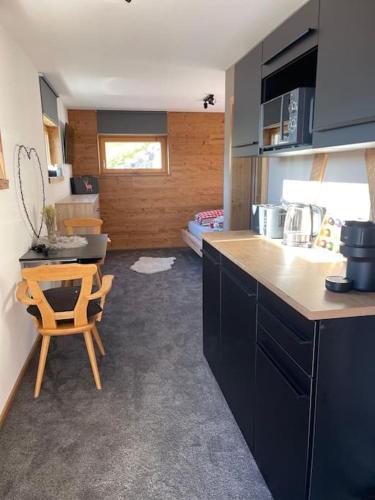 a kitchen with a counter and a chair in a room at Apartment direkt an der Piste in Damuls