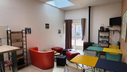 a room with colorful chairs and tables and a window at la ferme des ruelles in Moigny