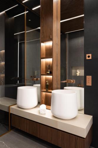 une salle de bain avec trois lavabos et deux miroirs dans l'établissement HIGHSTAY - Luxury Serviced Apartments - Invalides, à Paris
