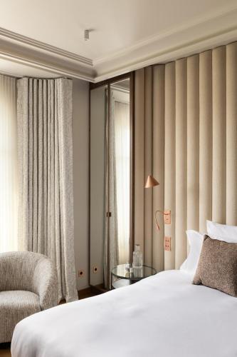 une chambre avec un lit, une chaise et une fenêtre dans l'établissement HIGHSTAY - Luxury Serviced Apartments - Invalides, à Paris