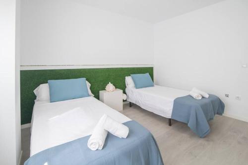 two beds in a room with blue and white at Espectacular piso con piscina, a 100 M de la playa in Cullera