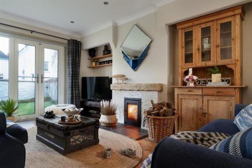 a living room with a fireplace and a tv at Quay House Luxury Living for 10 & Private Parking in Topsham