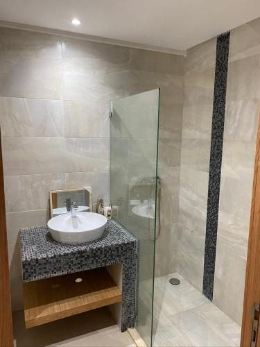a bathroom with a sink and a glass shower at Mansoria in Mohammedia