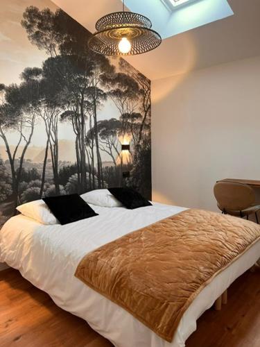 une chambre avec un lit avec un tableau sur le mur dans l'établissement L'abri Côtier, à Jard-sur-Mer