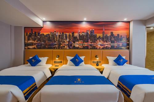 a hotel room with three beds and a painting at Super 8 Hotel Select Guangzhou Station Xicun Metro Station in Guangzhou