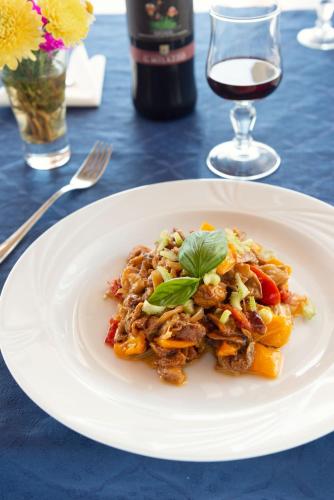 a plate of food on a table with a glass of wine at Eunymos Panarea in Panarea