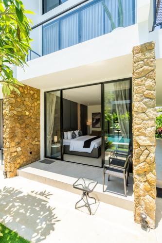 チャングーにあるThe R Apartments Pererenanのヴィラ内のベッドルーム(ベッド1台、椅子付)