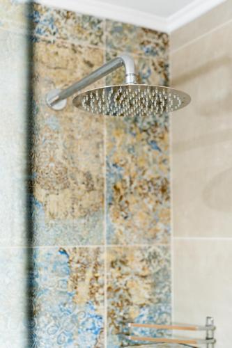 a shower with a shower head in a bathroom at Oasis Apartments Maggana Xanthi in Xanthi
