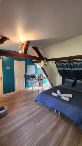 a bedroom with a bed and a table in a room at la ferme des ruelles in Moigny