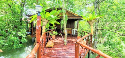 a wooden walkway leading to a house with plants on it at Phang Nga Bay Khanittha Homestay in Ban Khiam