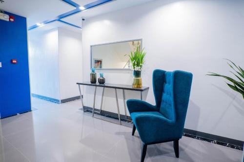 a room with a desk and a blue chair at Stacia Hotel in Cebu City