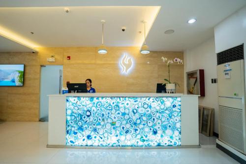 a woman sitting at a counter in a hospital lobby at Stacia Hotel in Cebu City