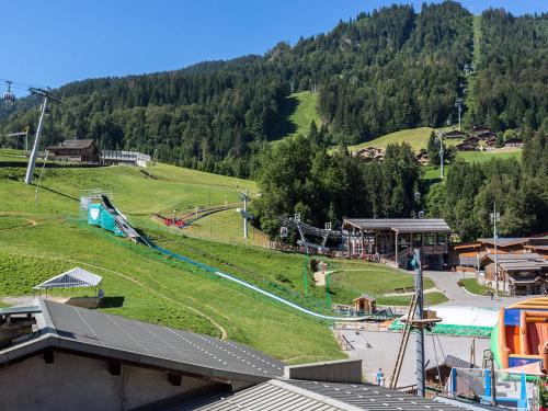 - une vue sur un parc avec une aire de jeux sur une colline dans l'établissement Appartement cosy 2 pièces, 4 pers, centre de La Clusaz, proche pistes, balcon et wifi - FR-1-437-52, à La Clusaz