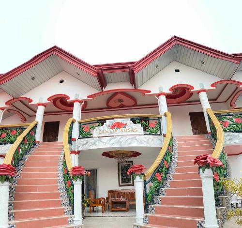 a building with a staircase with red flowers on it at ECB Guest House in Siquijor
