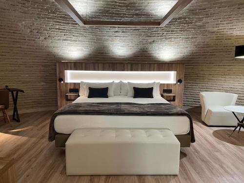 a bedroom with a bed and a brick wall at Hotel Maria Cristina in Toledo