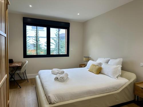 une chambre avec un grand lit blanc avec des serviettes dessus dans l'établissement Villa du Canon, à Lège-Cap-Ferret