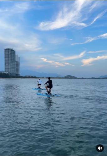 two people on paddle boards in the water at Dan's house in Kinh Dinh