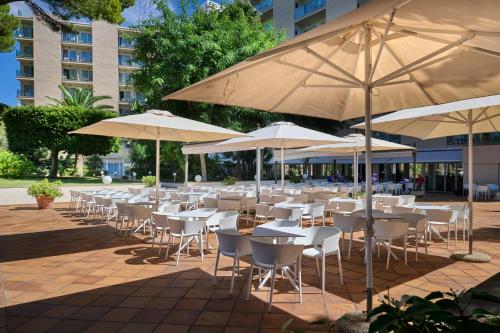 a group of tables and chairs with umbrellas at Grupotel Orient in Playa de Palma