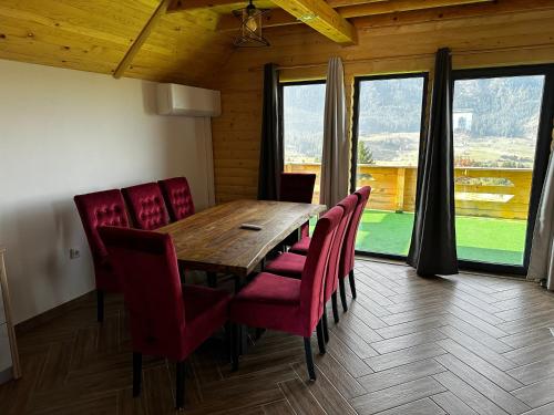 a dining room with a wooden table and red chairs at Vlasic Odmor - Villa Vlasicka Bajka in Vlasic