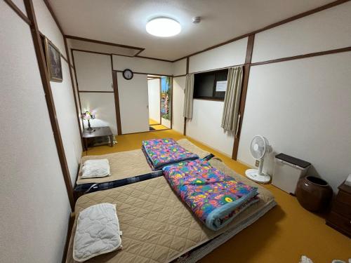 a room with two beds and a lamp in it at AnNam Stay Osaka Airport - whole two story house rental in Toyonaka