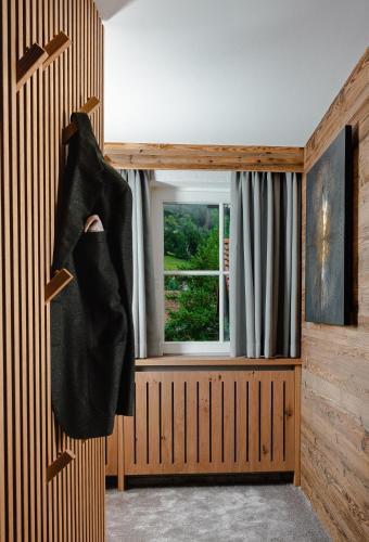a coat hanging on a wall next to a window at Hotel Alpenkönig in Oberstaufen