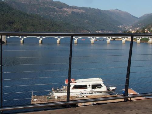 a boat on the water near a bridge at Ancoradouro T1 - Alojamento Local Gerês in Braga