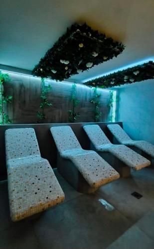 three benches in a waiting room with green lights at Apartman Zdravkovic & SPA in Veliko Gradište