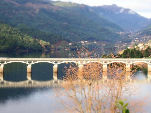 a bridge over a body of water with mountains at Ancoradouro T1 - Alojamento Local Gerês in Braga