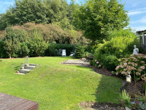 a garden with a lawn and some bushes and trees at Erholung am Deich in Glückstadt