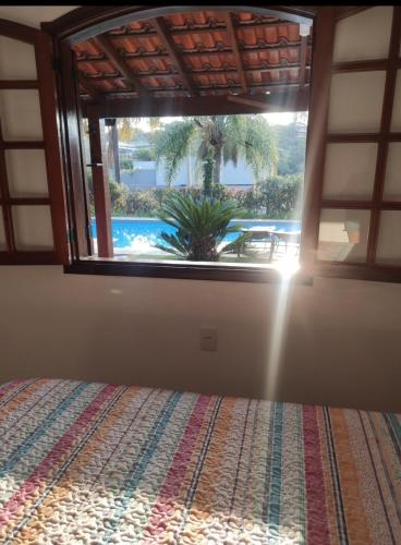 a bedroom with a window looking out at a pool at Casa de Campo com Piscina in Itupeva