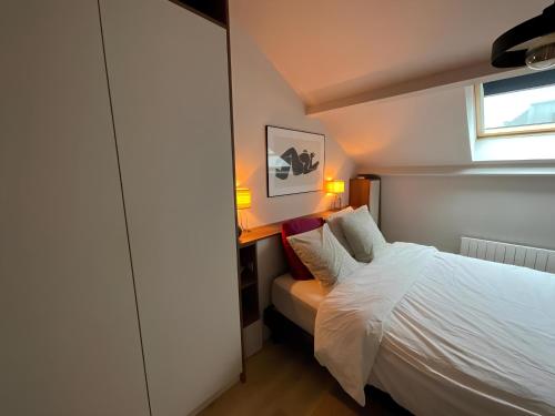 une petite chambre avec un lit et une fenêtre dans l'établissement LOFT DE JULIETTE à Saint-Malo, à Saint-Malo