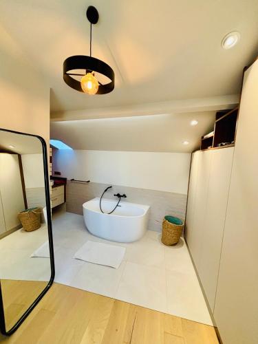 une salle de bain avec une baignoire et un miroir dans l'établissement LOFT DE JULIETTE à Saint-Malo, à Saint-Malo