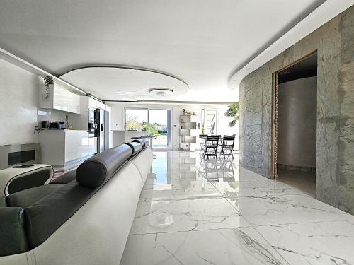 Il comprend un salon avec un grand canapé et une cuisine. dans l'établissement Maison Sapiac - 4pers - 2 chambres - 3 lits - Clim réversible - Terrasse ombragée et grand jardin - Piscine saison estivale, à Montauban