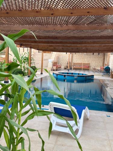 a swimming pool with a chair and a table at Pidgeon Lodge - Tunis Village in Tunis