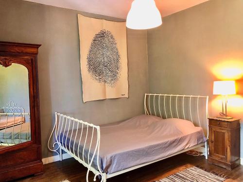 Bett in einem Zimmer mit Spiegel und Lampe in der Unterkunft Le Dort'Thouars - bord de rivière et bain nordique in Thouars