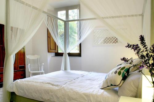 een slaapkamer met een hemelbed en een raam bij Villa Vittorio in Bagni di Lucca