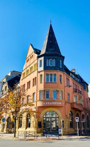 Un grand bâtiment avec une tour en haut dans l'établissement La Brasserie Hostel, à Metz