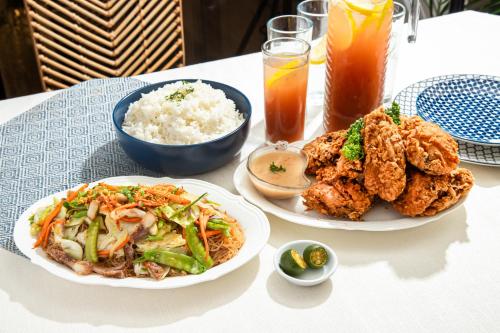two plates of food on a table with rice at Airo Hotel Manila in Manila