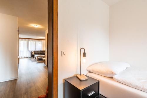 a bedroom with a bed and a lamp on a table at Fabi`s Horu Lodge in Zermatt