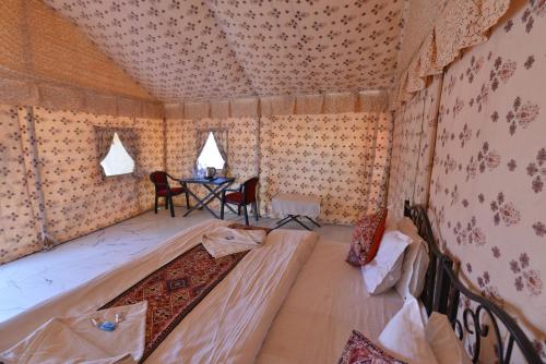 a room with a bed and a table in it at Melody Moon Desert Camp & Resort in Jaisalmer