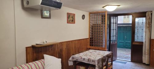 Habitación con mesa y puerta verde en Casa Cima Villa, en Ardesio