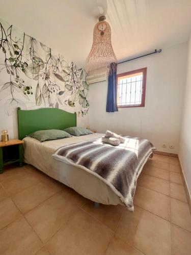 - une chambre avec un lit à tête verte dans l'établissement Superbe appartement vue mer proche de la plage avec piscine, à Pietra Moneta