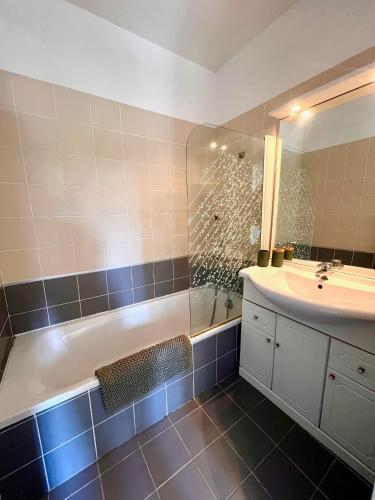 une salle de bain avec une baignoire, un lavabo et une douche dans l'établissement Superbe appartement vue mer proche de la plage avec piscine, à Pietra Moneta