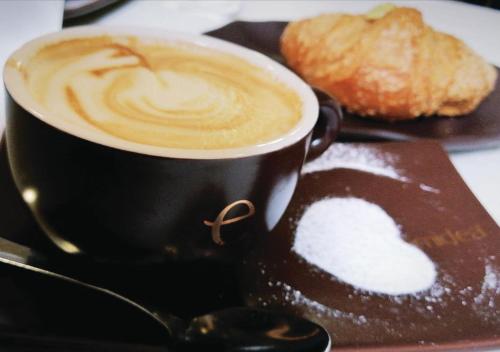 een kop koffie en een gebakje op een bord bij B&B Del Corso in Sannicandro di Bari